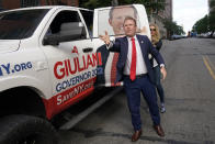 Republican gubernatorial candidate Andrew Giuliani throws car keys to an aide as he arrives to his polling place in a truck with his likeness on the side in New York, Tuesday, June 28, 2022. New Yorkers are casting votes in a governor's race that for the first time in a decade does not include the name "Cuomo" at the top of the ticket. The most prominent name for Democrats is Kathy Hochul while GOP candidates include Giuliani, the son of New York's former mayor. (AP Photo/Seth Wenig)