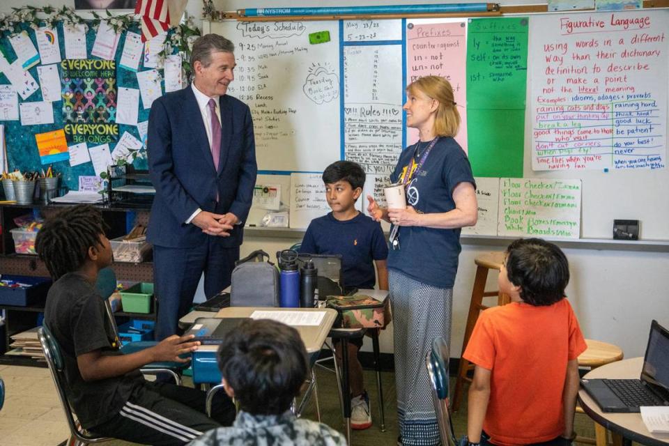 Gov. Roy Cooper visits a fourth-grade class while touring Washington Magnet Elementary School in Raleigh Tuesday, May 23, 2023. Cooper says state lawmakers would ‘starve’ public education with universal private school vouchers, more tax cuts and small raises for veteran teachers.