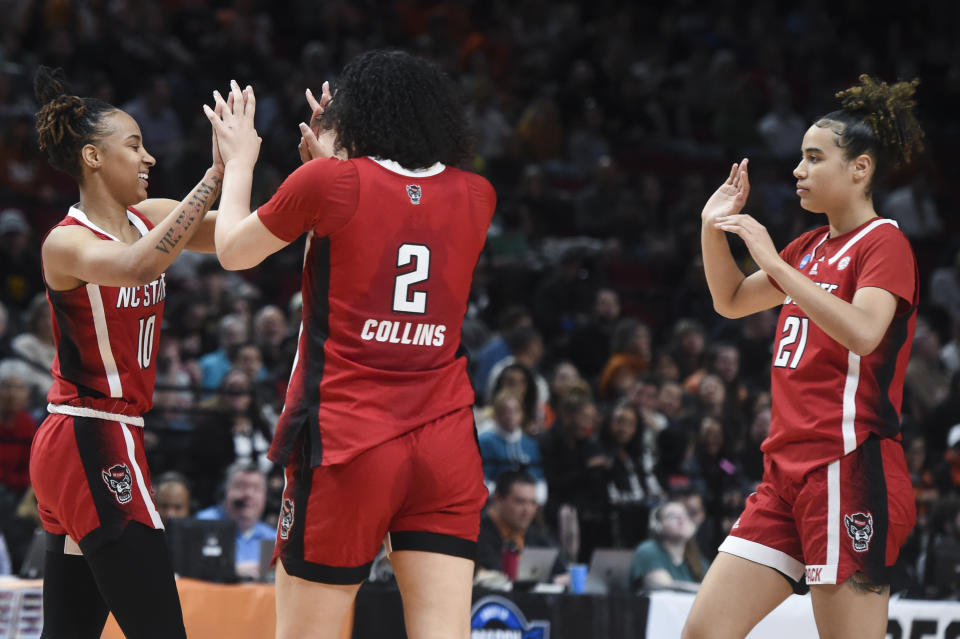 North Carolina State guard Aziaha James (10) celebrates a basket with Mimi Collins (2) and Madison Hayes (21) during the first half of the team's Elite Eight college basketball game against Texas in the women's NCAA Tournament, Sunday, March 31, 2024, in Portland, Ore. (AP Photo/Steve Dykes)