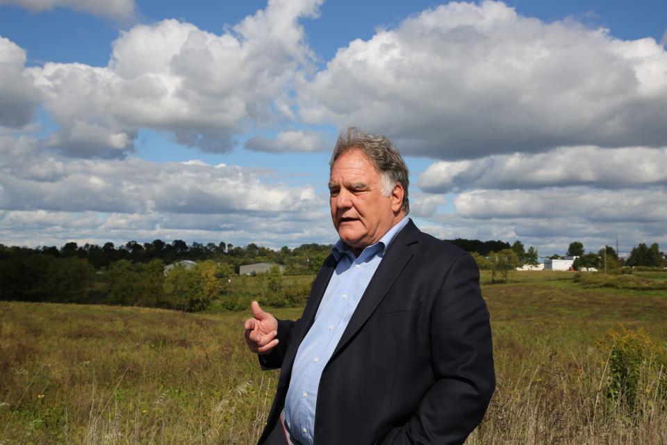 Bill Pleban stands in a field.