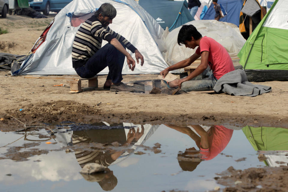 Migrants try to light a fire