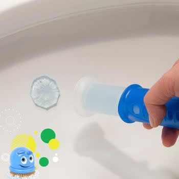 A hand stamping the circle of gel in the toilet