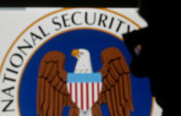 FILE PHOTO: A man is silhouetted near logo of the U.S. National Security Agency (NSA) in this photo illustration taken in Sarajevo March 11, 2015. REUTERS/Dado Ruvic/File Photo