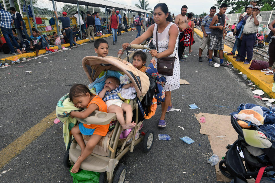 Una migrante hondureña participa en la caravana que intenta cruzar a México para seguir camino a EEUU, en el puente fronterizo que une la ciudad guatemalteca de Tecún Umán con la mexicana Ciudad Hidalgo, el 20 de octubre de 2018