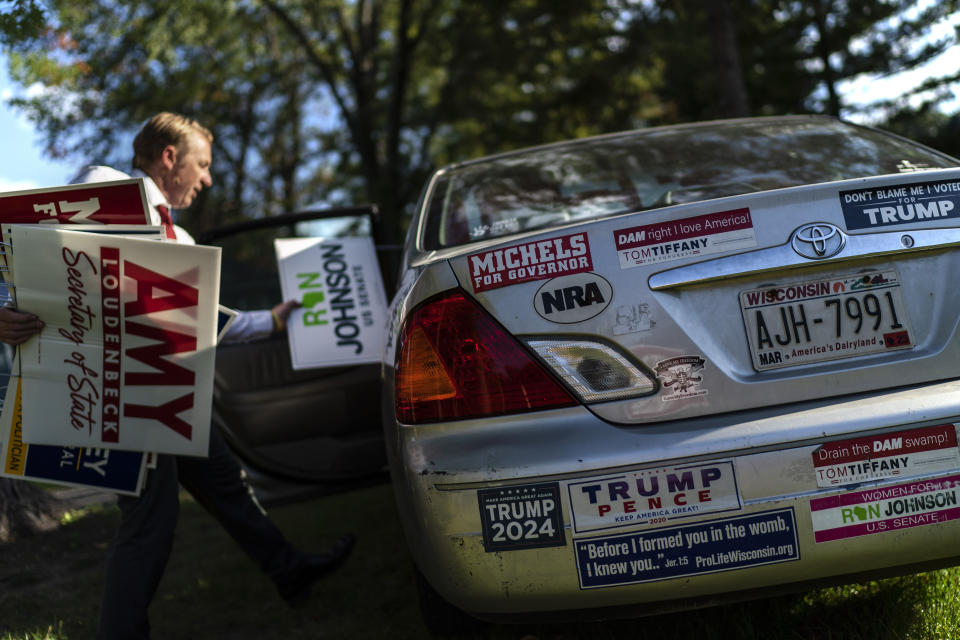 St. Croix County Republican Party Chairman Matt Bocklund loads campaign signs into his car as he drives around to place them on lawns in Hudson, Wis., Thursday, Sept. 29, 2022. Despite midterm elections that failed to see the sweeping Republican victories that many had predicted, a growing right-wing conservative movement in the county remains a cornerstone of the conservative electoral base. (AP Photo/David Goldman)