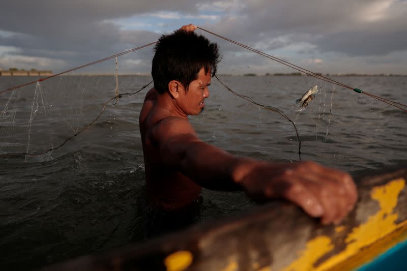 The Wider Image: Rising seas threaten early end for sinking village in Philippines