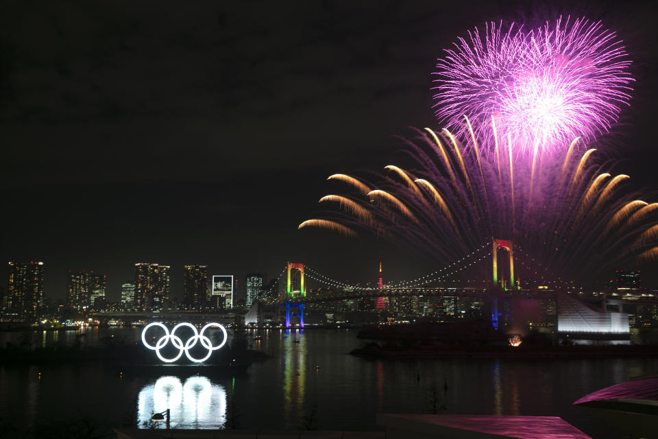 Fireworks light up the sky near the illuminated Olympic rings during a ceremony held to celebrate the 6-months-to-go milestone for the Tokyo 2020 Olympics Friday, Jan. 24, 2020, in the Odaiba district of Tokyo. (AP Photo/Jae C. Hong)