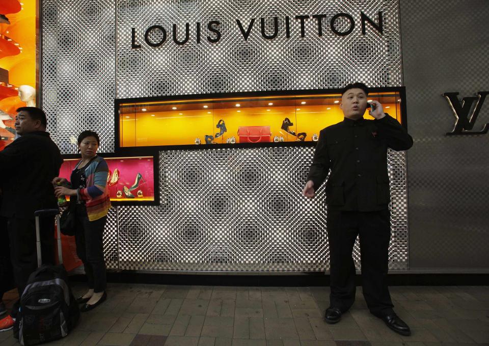 Howard talks on his mobile phone as he appears as a Kim Jong-un lookalike on a street at Hong Kong's Tsim Sha Tsui shopping district