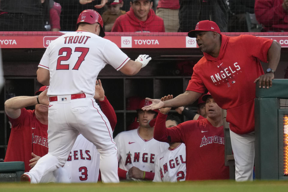 Los Angeles Angels' Mike Trout (27) returns to the dugout after scoring off of a single hit by Luis Rengifo during the first inning of a baseball game against the Washington Nationals in Anaheim, Calif., Monday, April 10, 2023. Hunter Renfroe also scored. (AP Photo/Ashley Landis)