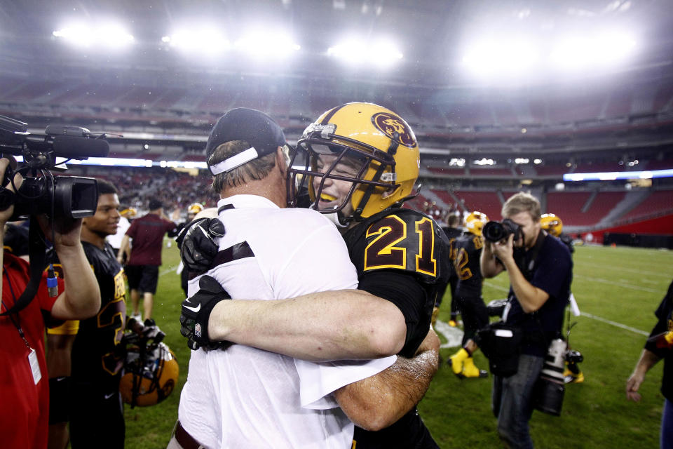 Mountain Pointe's head coach Norris Vaughan (cq) embraces Timmy Hernandez (cq) after winning the Division I Championship game at University of Phoenix Stadium in Glendale, AZ on Nov. 30, 2013. Patrick Breen/The Republic