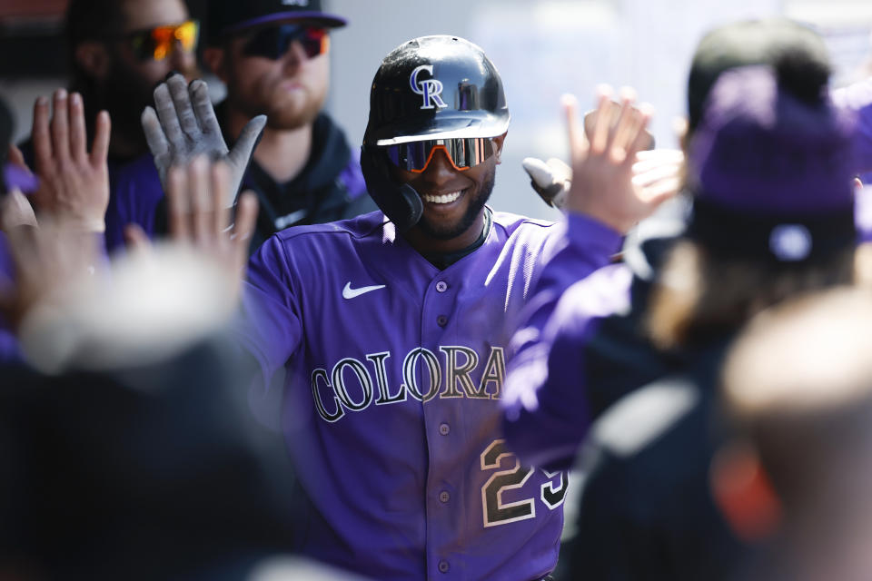 Colorado Rockies' Jurickson Profar celebrates in the dugout after scoring on a single by Kris Bryant off Cleveland Guardians starting pitcher Tanner Bibee during the sixth inning of a baseball game, Wednesday, April 26, 2023, in Cleveland. (AP Photo/Ron Schwane)