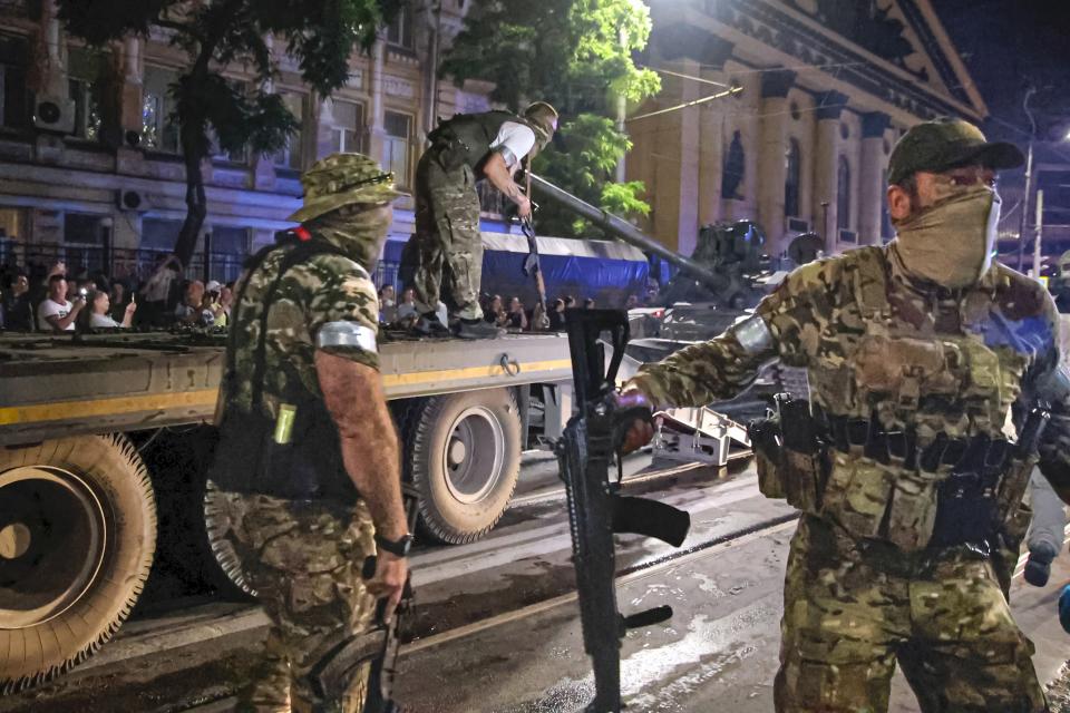 FILE - Members of the Wagner Group military company guard an area as other load their tank onto a truck on a street in Rostov-on-Don, Russia, Saturday, June 24, 2023, prior to leaving an area at the headquarters of the Southern Military District. Russia's rebellious mercenary chief Yevgeny Prigozhin walked free from prosecution for his June 24 armed mutiny. In the meantime, a campaign appears to be underway to portray the founder of the Wagner Group military contractor as driven by greed. (Vasily Deryugin, Kommersant Publishing House via AP, File)