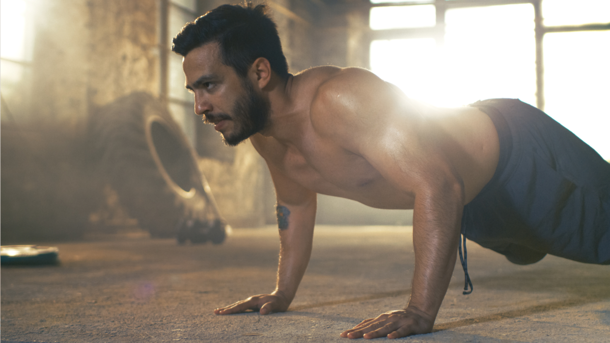  Man doing tabata-style hiit workout, performing the push up. 