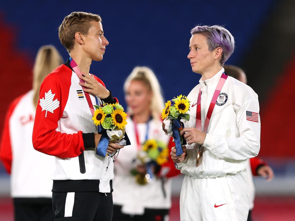 Canada's Quinn speaks with USWNT's Megan Rapinoe.