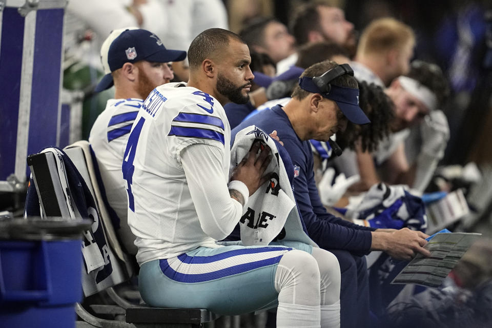 Dallas Cowboys quarterback Dak Prescott (4) sits on the bench while Houston Texans are on offense in the second half of an NFL football game, Sunday, Dec. 11, 2022, in Arlington, Texas. (AP Photo/Tony Gutierrez)