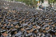 <p>Stilles Gedenken. Beamte der New Yorker Polizei trauern um einen getöteten Kollegen. Dessen Familie verlässt gerade die World Changers Church nach dem Beerdigungsgottesdienst in der Bronx. (Bild: AP Photo/Mary Altaffer) </p>