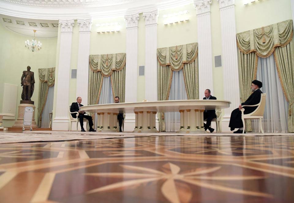 Russian President Vladimir Putin, left, and Iranian President Ebrahim Raisi, right, talk to each other during their meeting in the Kremlin in Moscow, Russia, Wednesday, Jan. 19, 2022. (Pavel Bednyakov, Sputnik, Kremlin Pool Photo via AP)