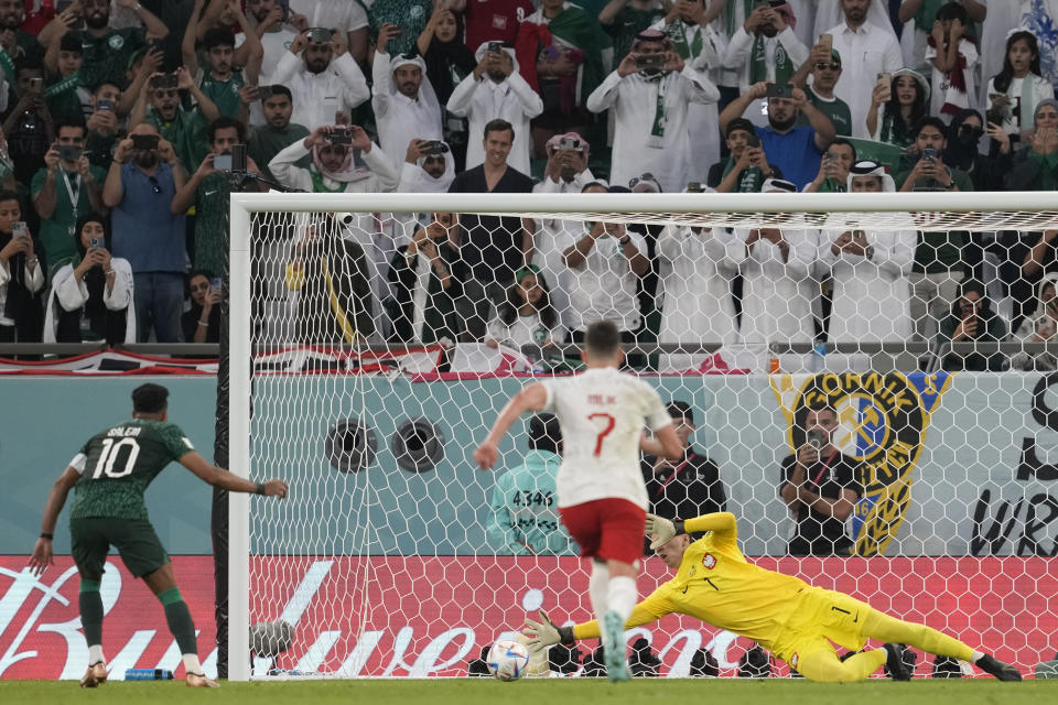 Poland's goalkeeper Wojciech Szczesny saves a penalty kick by Saudi Arabia's Salem Al-Dawsari during the World Cup group C soccer match between Poland and Saudi Arabia, at the Education City Stadium in Al Rayyan , Qatar, Saturday, Nov. 26, 2022. (AP Photo/Darko Vojinovic)