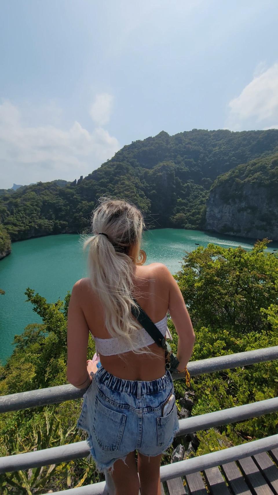 A woman taking in the mountainous and water views of Thailand.