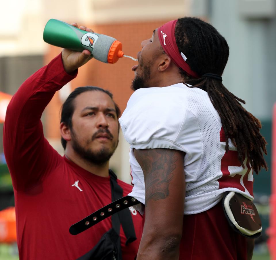 Clayton Smith gets a drink from a trainer between drills as the University of Oklahoma Sooners (OU ) hold fall football camp outside Gaylord Family/Oklahoma Memorial Stadium on  Aug. 8, 2022 in Norman, Okla.  [Steve Sisney/For The Oklahoman]