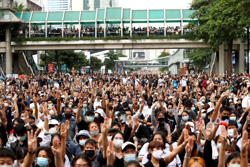 Pro-democracy protesters show the three-finger salute as they gather demanding the government to resign and to release detained leaders in Bangkok