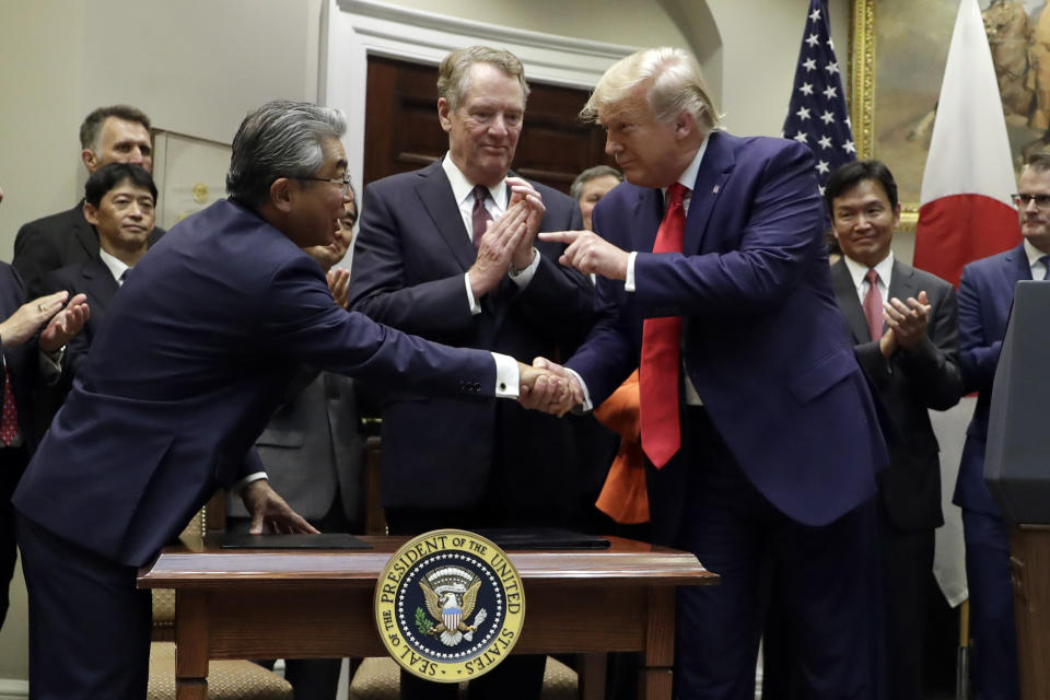 President Donald Trump points to Japanese Ambassador to the United States Shinsuke Sugiyama, left, as U.S. Trade Representative Robert Lighthizer, center, watches at the end of a signing ceremony for a trade agreement with Japan in the Roosevelt Room of the White House, Monday, Oct. 7, 2019, in Washington. (AP Photo/Evan Vucci)