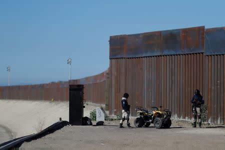 Private security guards stand guard in front of the border fence between Mexico and United States, in Tijuana, Mexico November 16, 2018. REUTERS/Carlos Garcia Rawlins