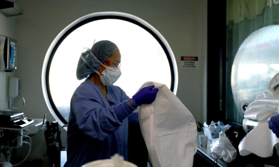 A nurse cleans personal protective equipment after being part of a team that treated a coronavirus in San Jose, California.