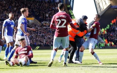 A fan is restrained by a steward and players after invading the pitch and attacking Aston Villa's Jack Grealish during the match - Credit: &nbsp;Action Images via Reuters