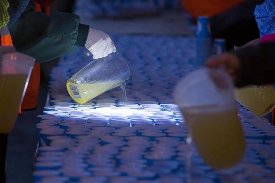 Volunteers fill water glass before the start of the California International Marathon (CIM) in Fair Oaks Ca, Sunday Dec 3, 2017.