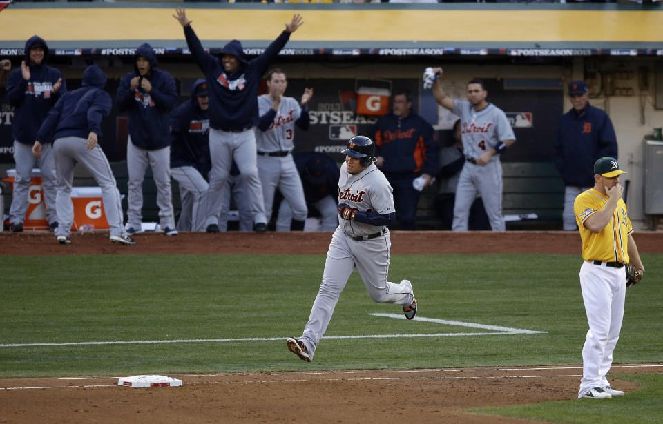 FILE - The Detroit Tigers dugout celebrates as Miguel Cabrera, center, rounds the bases after hitting a two-run home run off Oakland Athletics pitcher Sonny Gray during the fourth inning of Game 5 of an American League baseball division series in Oakland, Calif., Oct. 10, 2013. Athletics first baseman Brandon Moss, right, reacts. Miguel Cabrera, one of the greatest hitters of all time, is retiring after the Tigers wrap up their season Sunday, Oct. 1, 2023, and baseball’s last Triple Crown winner is leaving a lasting legacy in the game and his native Venezuela. (AP Photo/Jeff Chiu, File)