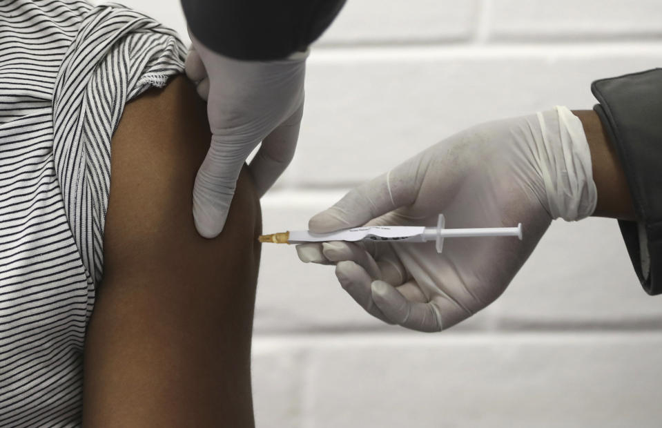 FILE - In this Wednesday, June 24, 2020 file photo, a volunteer receives an injection at the Chris Hani Baragwanath hospital in Soweto, Johannesburg. This is part of Africa's first participation in a COVID-19 vaccine trial developed at the University of Oxford in Britain in conjunction with the pharmaceutical company AstraZeneca. (Siphiwe Sibeko/Pool via AP)