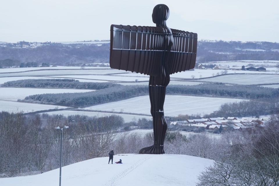 People sledging in the snow at the foot of Antony Gormley’s Angel of the North sculpture in Gateshead, Tyne and Wear (Owen Humphreys/PA) (PA Wire)