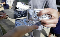 Packets of sunscreen along with paper fans are offered to spectators during Tennessee Titans NFL football training camp Tuesday, Aug. 7, 2018, in Nashville, Tenn. (AP Photo/Mark Humphrey)