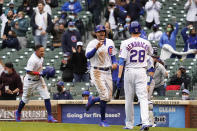 Chicago Cubs' Ildemaro Vargas, left and Jake Marisnick, center, celebrate after scoring on a wild pitch against the Los Angeles Dodgers as Kyle Hendricks (28) stands nearby during the third inning of the first baseball game of a doubleheader Tuesday, May, 4, 2021, in Chicago. (AP Photo/David Banks)