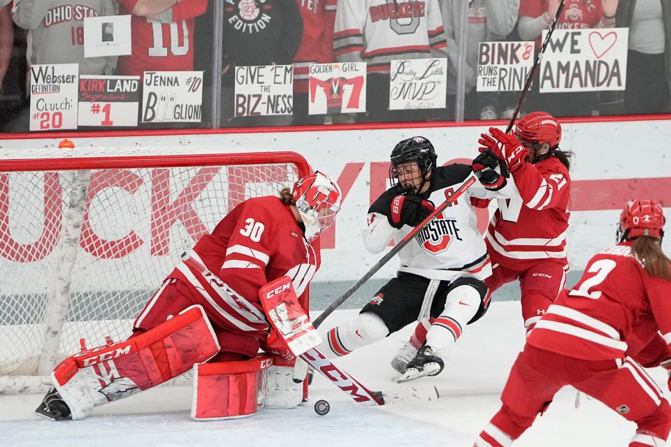 Jan 13, 2023; Columbus, Ohio, USA;  Ohio State Buckeyes forward Gabby Rosenthal (15) gets hit by Wisconsin Badgers defenseman Nicole LaMantia (21) as she crashes into the crease of goaltender Cami Kronish (30) during the NCAA women's hockey game at the OSU Ice Rink. Ohio State won 2-1 in overtime. Mandatory Credit: Adam Cairns-The Columbus Dispatch