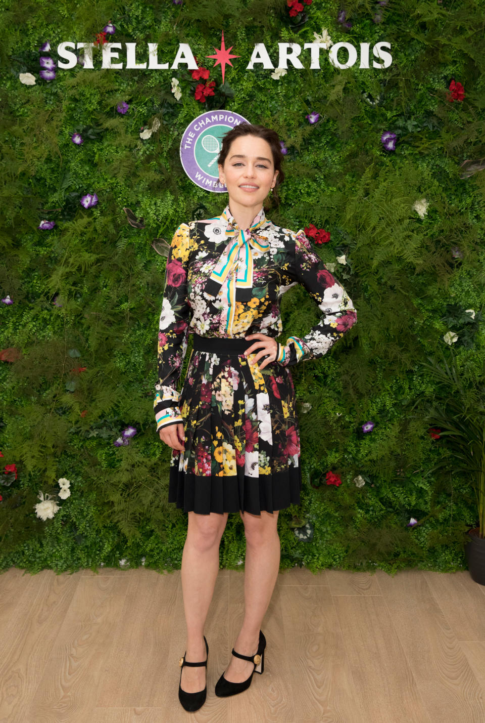 <p>„Game of Thrones“-Kollegin Emilia Clarke erschien in einem knielangen bunten Langarmkleid mit floralem Print und Statement-Schleife am Kragen. (Bild: Getty Images) </p>