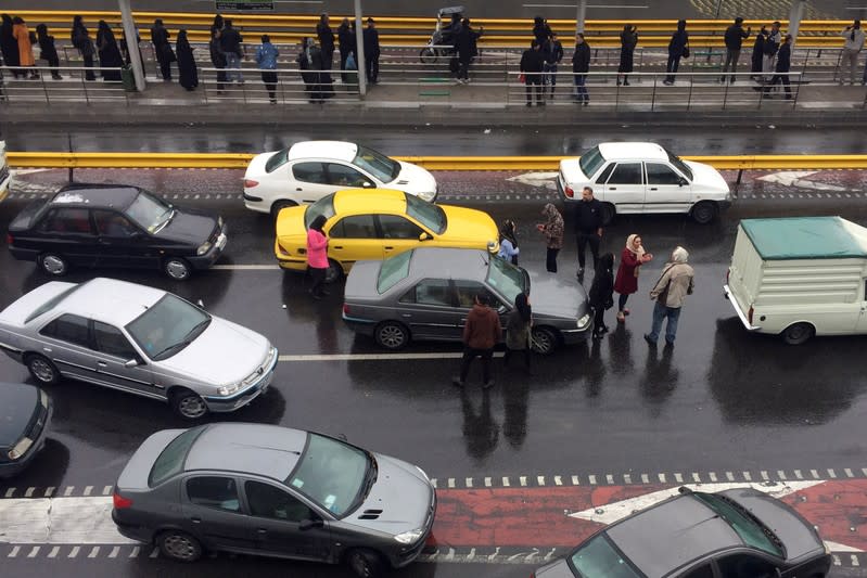 People stop their cars in a highway to show their protest against increased gas price in Tehran