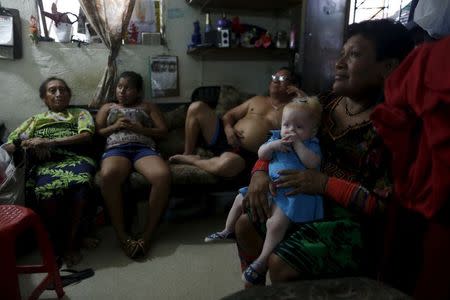 Eight-month-old Aisha Guerrero, who is part of the albino or "Children of the Moon" group in the Guna Yala indigenous community, sits on her Aunt's lap in Panama City, Panama May 9, 2015. REUTERS/Carlos Jasso SEARCH "JASSO MOON" FOR ALL IMAGES