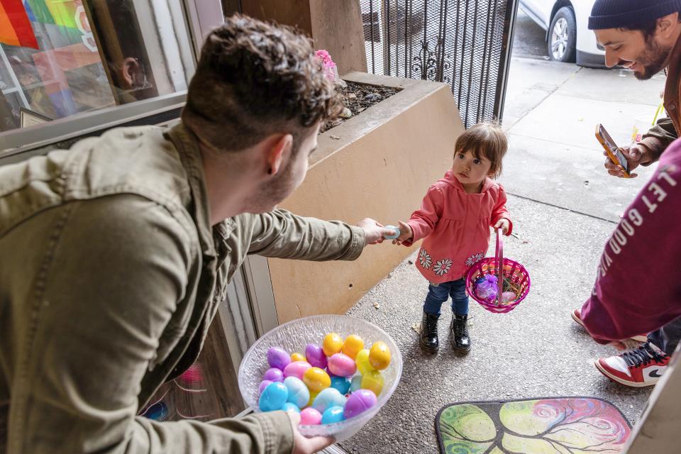 James Patnaude, transgender service coordinator, hands an egg to Abigail Magallon, 2, at the Yosemite Street Village's 2nd Annual Easter Egg Hunt on Saturday, April 16, 2022, in Stockton.