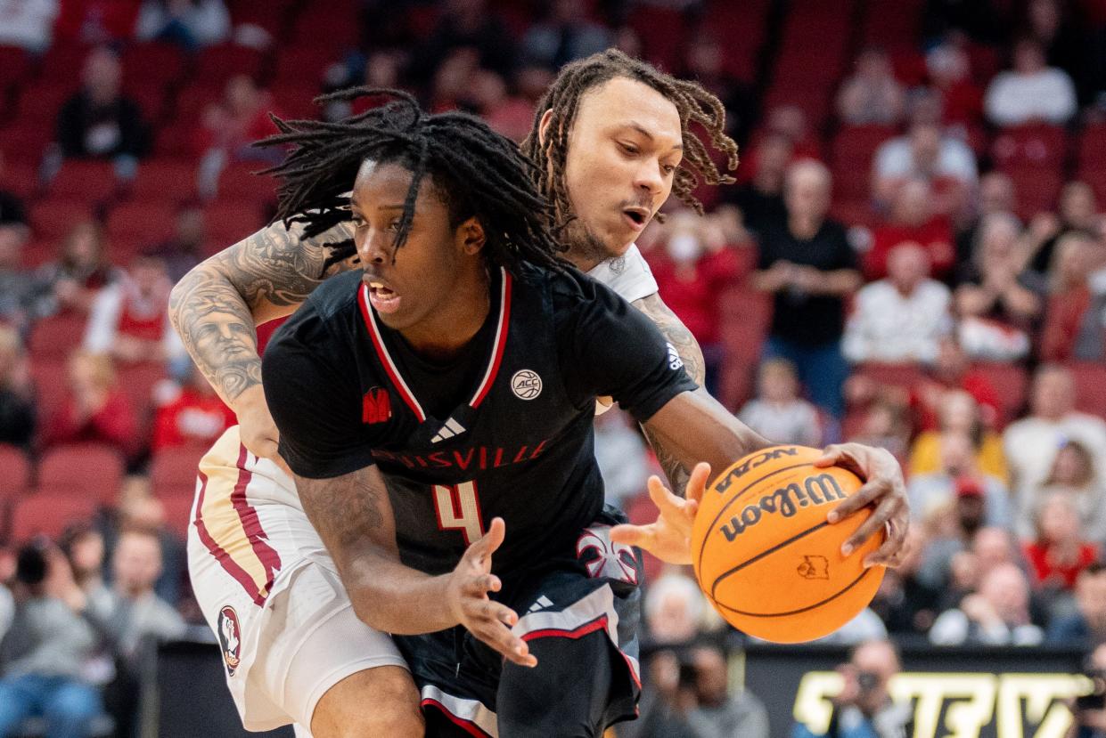 Cardinals guard Ty-Laur Johnson dribbles past Seminoles guard Josh Nickelberry. Johnson had 27 points and 11 assists Saturday night.