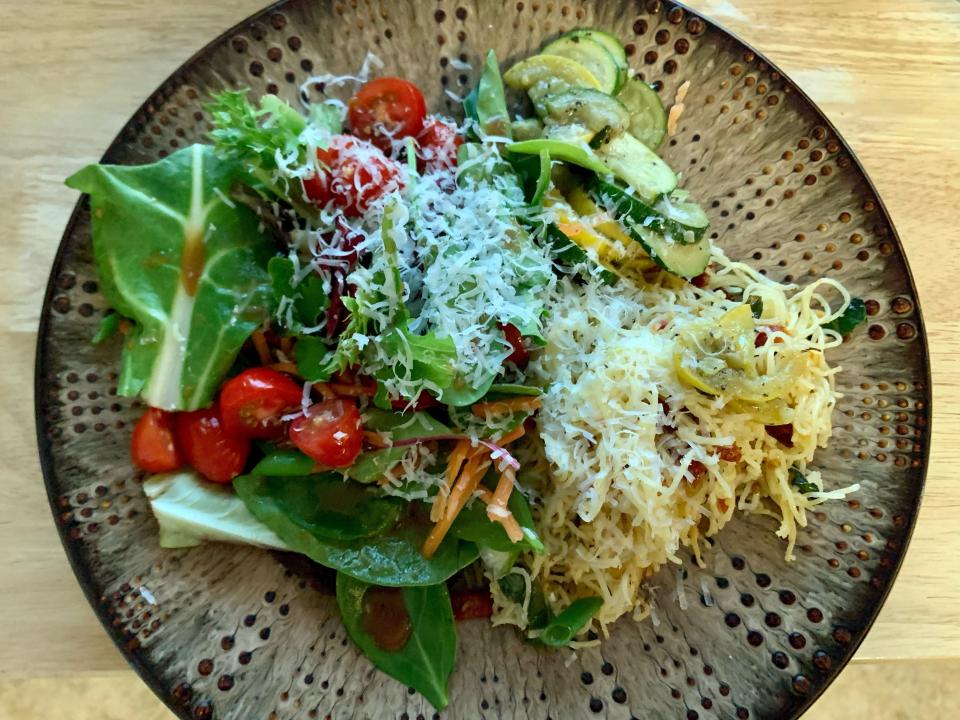 colorful salad with cheese and tomatoes on brown plate