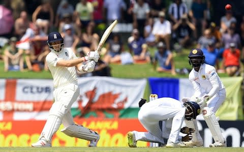 England's captain Joe Root (L) plays a shot as Sri Lanka's wicketkeeper Niroshan Dickwella (R) looks on during the third day of the second Test match between Sri Lanka and England at the Pallekele International Cricket Stadium in Kandy - Credit: Getty images