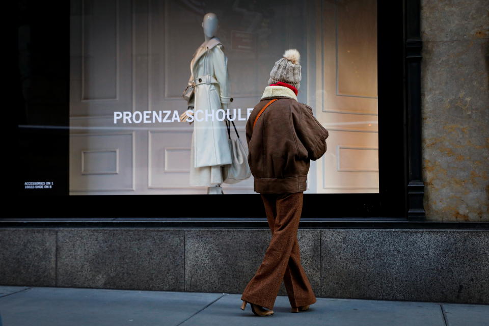 A woman looks at a window featuring fashion by Proenza Schouler at Saks 5th Ave, during the coronavirus disease (COVID-19) pandemic, in New York, U.S., February 17, 2021.  REUTERS/Brendan McDermid