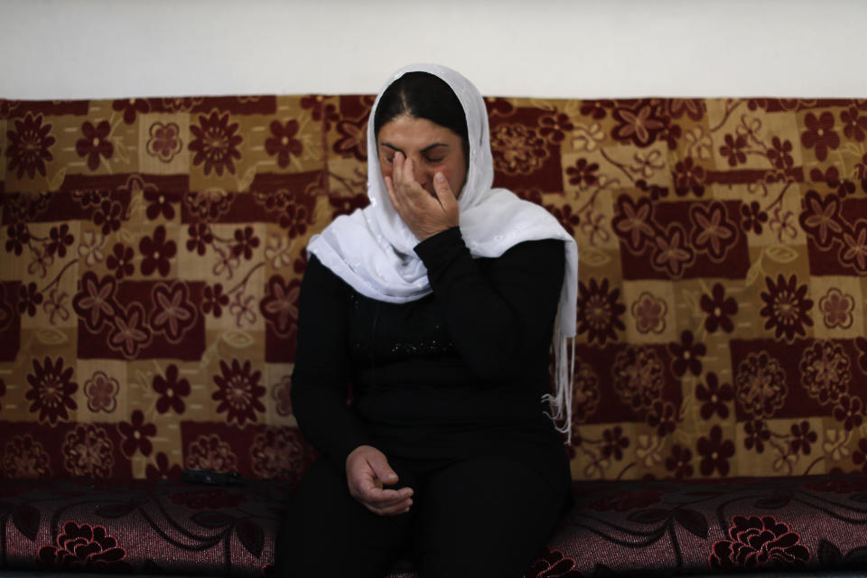 In this Thursday, Oct. 4, 2018 photo, Maysoun Saab, 39, who lost her mother, father, brother as well as 34 members of her extended family in a July 25 Islamic State attack, cries as speaks during an interview with The Associated Press in the her house at the village of Shreihi in the southern province of Sweida, Syria. Three months after a stunning Islamic State attack on a southeastern corner of Syria in which more than 200 people were killed and 30 women and children abducted, tensions are boiling over, and young men are taking up arms. It is a stark change for a province that managed to stay on the sidelines of the seven-year Syrian war and where most villagers worked grazing livestock over surrounding hills. (AP Photo/Hassan Ammar)