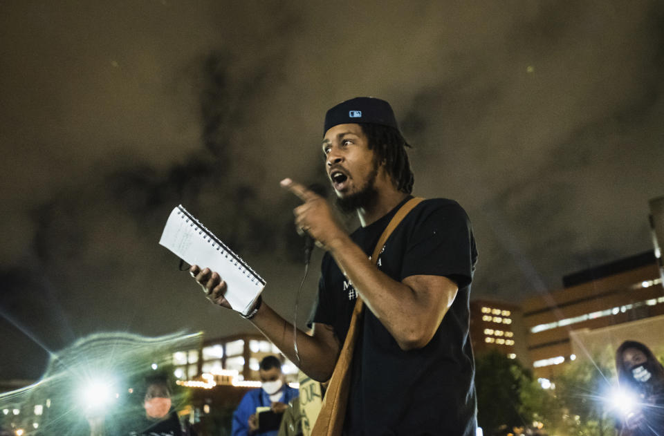 Tre Stubbs, son of John Neville, recites a poem he wrote about his father during a vigil for Neville on Wednesday, Aug. 5, 2020, in Bailey Park in Winston-Salem, N.C. Demonstrators held the vigil to demand justice for Neville, a Black man who died days after his arrest following the release of body camera videos that showed him struggling with guards and yelling he couldn’t breathe as they restrained him. (Allison Lee Isley/The Winston-Salem Journal via AP)