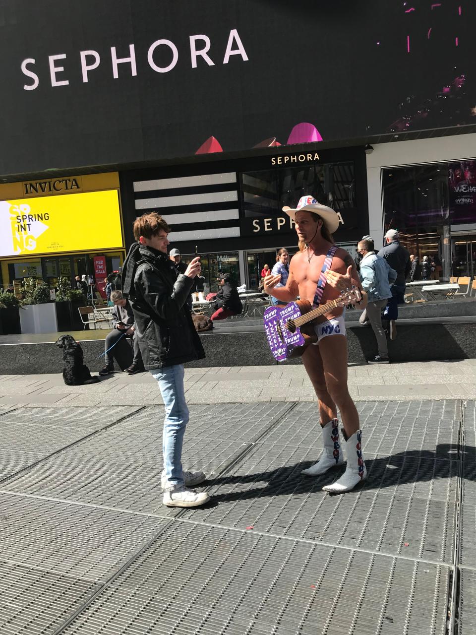 Robert Burk, 49, has performed as the Naked Cowboy in Times Square for 20 years. Here, he talks to a tourist on a slow Monday.