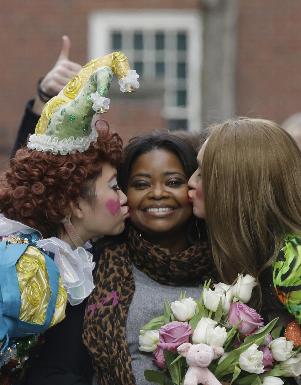 Guan-Yue Chen, Hasty Pudding Theatricals President, left, and Dan Milashewski, vice president, kiss actress Octavia Spencer during a parade to honor Spencer as the Hasty Pudding Theatricals Woman of the Year Thursday, Jan. 26, 2017, in Cambridge, Mass. (AP Photo/Stephan Savoia)