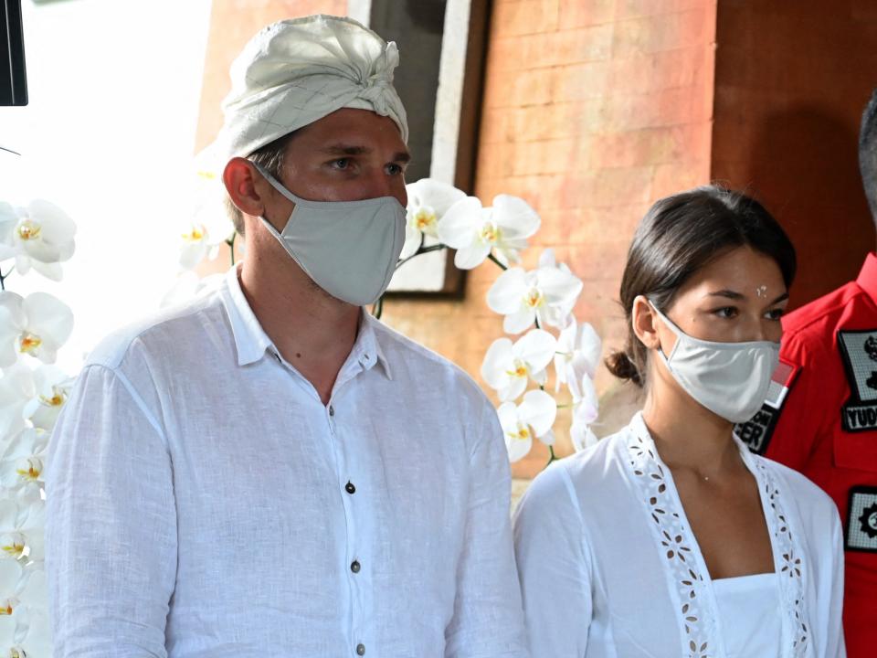 Russia's Alina Fazleeva (C) and her husband Andrey Fazleev (L) attend a press conference in Denpasar, on the Indonesian resort island of Bali on May 6, 2022, as they face deportation for taking nude photos on a sacred tree.