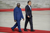 FILE - Solomon Islands Prime Minister Manasseh Sogavare, left, walks with Chinese Premier Li Keqiang during a welcome ceremony at the Great Hall of the People in Beijing, Wednesday, Oct. 9, 2019. Solomon Islands Prime Minister Sogavare has blamed foreign interference over his government's decision to switch alliances from Taiwan to Beijing for anti-government protests, arson and looting that have ravaged the capital in recent days.(AP Photo/Mark Schiefelbein, File)